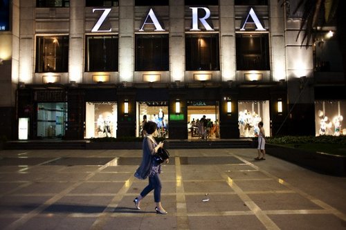 shopper walks past a Zara store along Huai Hai Road, one of the main ...